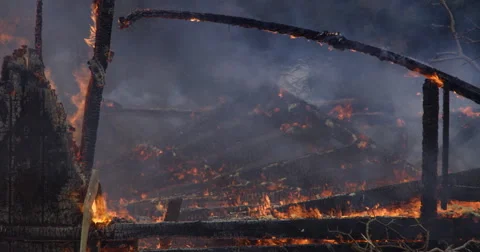 Low flames continue to consume charred wall framing and beams in the aftermath Stock Footage 59515229