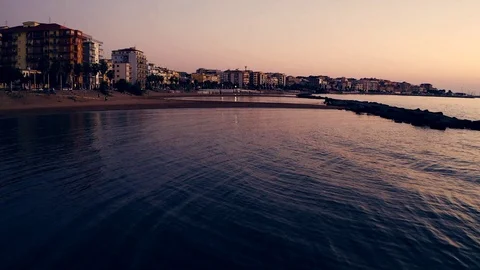 Low flight over a beach before the sunrise in a coastal city Stock Footage 120604297