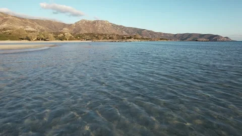 Low flight over crystal clear shallow water at Elafonisi, Crete Stock Footage 346723609