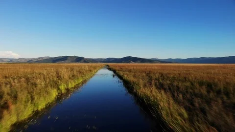Low Flight Over Irrigation Ditch in Sierra Valley CA - Aerial Drone Stock Footage 114055391