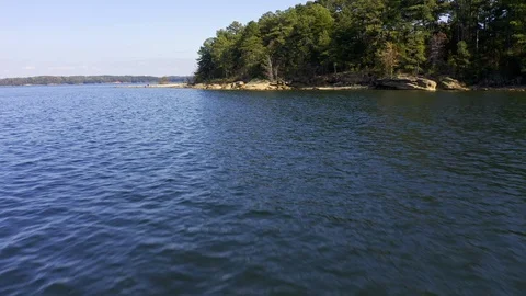 A low flight over lake waters toward the shore. Stock Footage 119298891