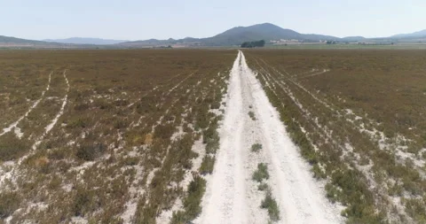 Low flight over road in dry lagoon in the desert Stock Footage 210434702