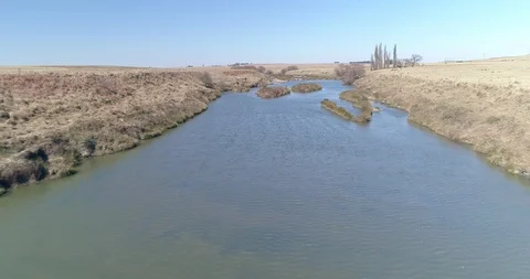 Low flight over shallow river with grass islands Stock Footage 93485930