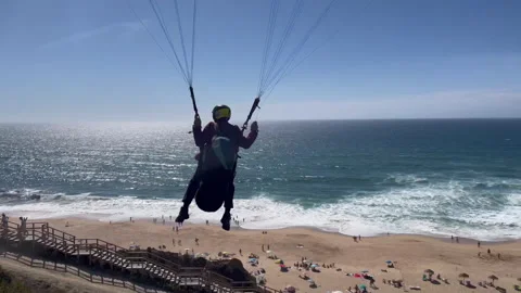 Low Flight Paragliding Passenger Over Ocean Beach Handheld Shot Video stock 249665316