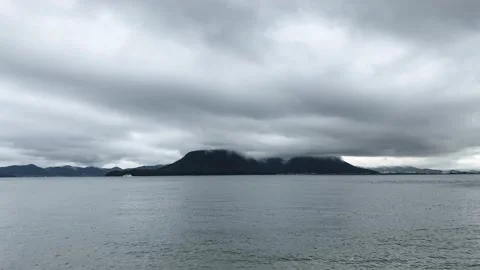 Low floating clouds on top over island mountain and ocean landscape Stock Footage 153464390