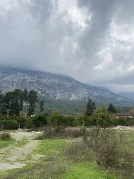 Low fluffy clouds hang over the high mountains, cover their peaks Stock Photos