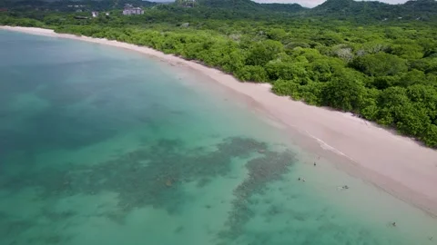 A low-flying 4K drone shot of Playa Conchal, or “Shell Beach”, and Puerto Stock Footage 257740655