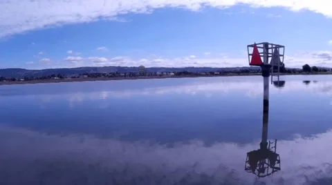 Low Flying Aerial Camera Tracks Over Calm Bay Waters Past Buoy Stock Footage 37579810
