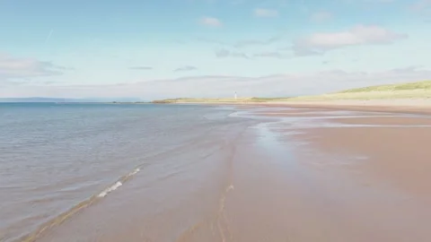 Low Flying Aerial View of Sandy Beach and Calm Coastal Waters Vídeos de archivo 333767884