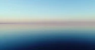 Low Flying Aerial View Of Water Reflection Over Lake At Sunset Stock Footage