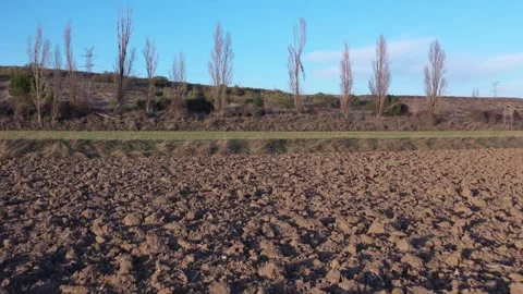 Low Flying Backward Drone Shot Over Plowed Field After Harvest in Winter Stock Footage 325223150