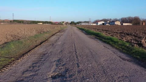 Low Flying Drone Advancing Over Damaged Rural Road in Countryside Stock Footage 325223159