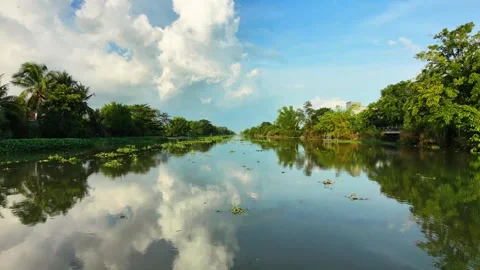 Low flying drone capturing clear sky reflection on a swelling river Stock-Footage 337697747