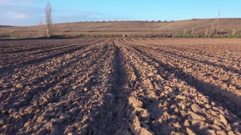Low Flying Drone Moving Forward Over Plowed Field After Harvest in Winter Stock Footage 325223149