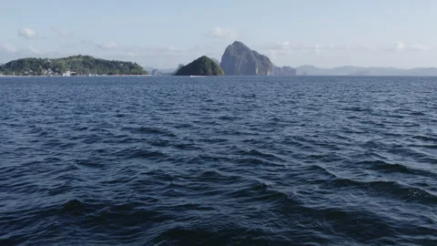 Low flying drone over water with tropical island in distance Stock Footage 272747474