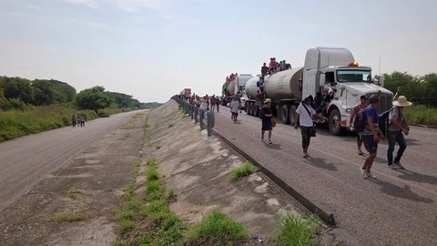 Low flying drone shot of migrant caravan lifting to high altitude 4K Editorial Video stock 109229633