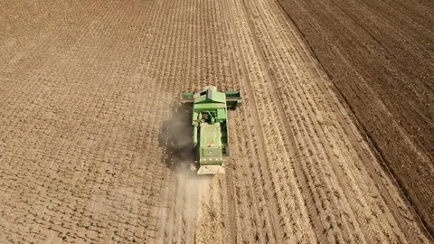 A low flying drone winging after a combine harvester collecting sunflower seeds. Stock-Footage 82472764