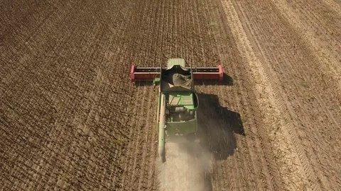 A low flying drone winging after a modern combine harvester collecting sunflower Stock Footage 82472841