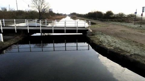 Low flying over canal bridge waterway railings with fresh mirror Stock Footage 125829933