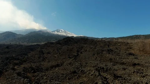 Low flying over lava rock revealing the summit of mount Etna in Sicily Stock Footage 104602913
