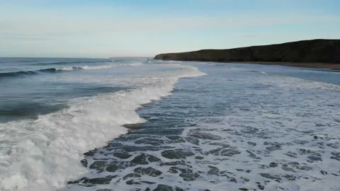 Low flying over waves on Watergate Bay Beach Stock Footage 134403693