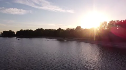 Low flyover of large lake at sunset Stock Footage 220901230