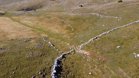 Low Flyover Past Unique Rock Formations Revealing Valley Floor and Steep Slo Stock Footage 321858951