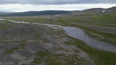 Low flyover of rocky arctic river on rolling tundra landscape, overcast Stock Footage 345417946