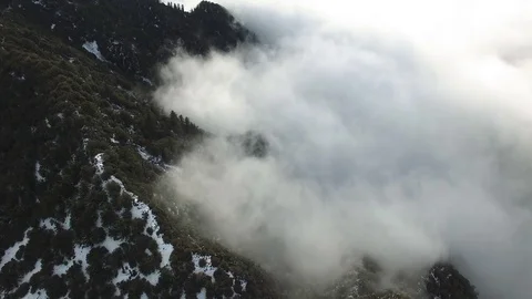 Low Fog Clouds Collide with the Snow Covered Mountains Stock-Footage 71551339