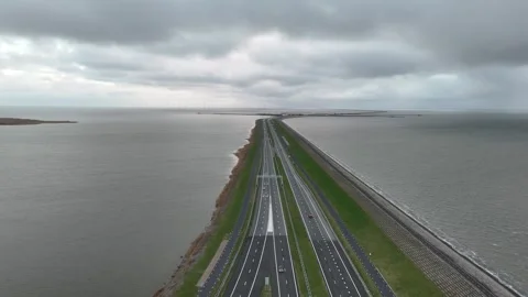 Low forward flight above dam traffic with sea on both sides Stock Footage 331828887
