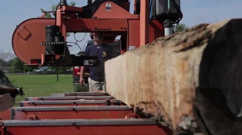 Low front angle portable sawmill blade cuts thru log Stock Footage 40472142
