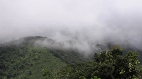 Low gray clouds, haze passing through the mountains and hills of green grass. Stock Footage 160277898
