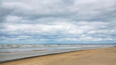 Low gray clouds over beach of Baltic Sea in autumn Stock Photos