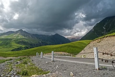 Low gray clouds over mountain road Stock Photos