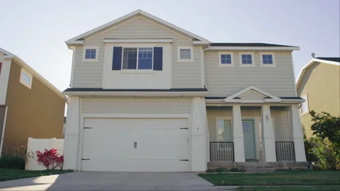 Low to ground sideways dolly establishing shot of craftsman house with sun flare Video stock 242133575