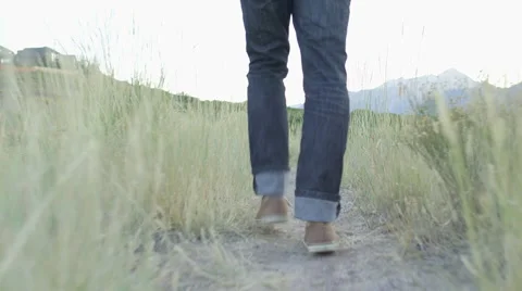 Low Handheld Tracking of Man Walking through Yellow Weeds 動画素材 68723654