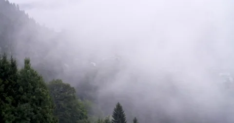 Low hanging clouds floating over over mountains in Austria Stock Footage 79773327