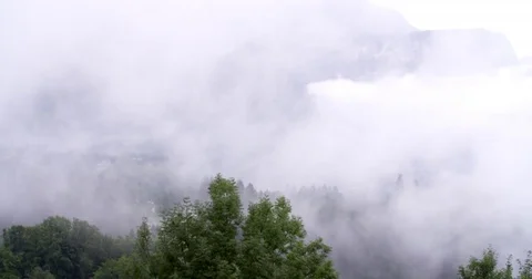 Low hanging mist clouds floating over over mountains in Austria Stock Footage 79761828