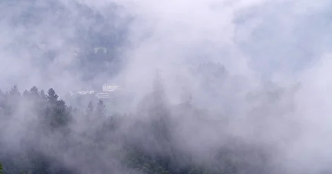 Low hanging mist clouds floating over over mountains in Austria Stock Footage 79761950