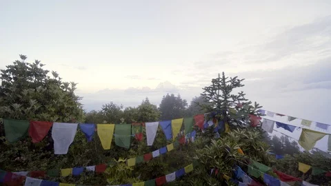 Low to high of prayer flags to reveal Himalayan mountains above the clouds Video stock 91434320