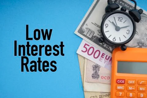 LOW INTEREST RATES text with alarm clock, banknotes currencies and calculator Stockfoto's