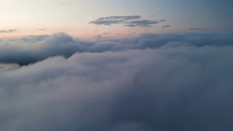 Low key aerial view evening flight above the clouds at blue hour after sunset Stock Footage 113927707