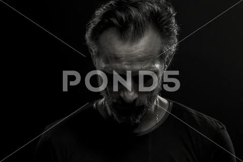 Low key dramatic portrait of mature man on black background. Stock Photos