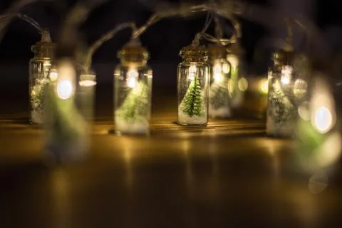 Low key Image of christmas tree in mason jar with garland warm lights Stock Photos