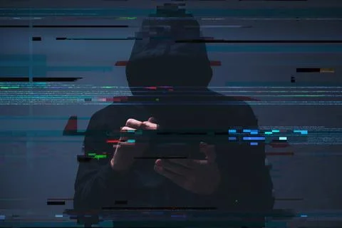 Low-key image of a hooded hacker typing on a smartphone, with digital code .. Stock Photos