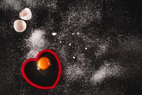 Low key image of a white raw organic eggs on black background sprinkled with Foto stock