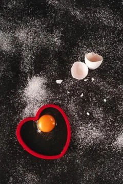 Low key image of a white raw organic eggs on black background sprinkled with Stock Photos
