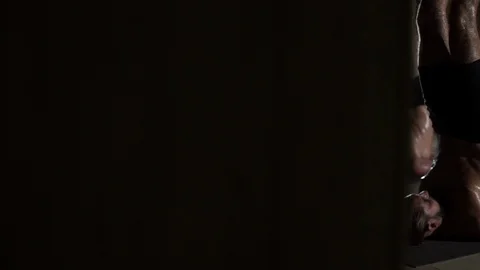 Low key strong men practice yoga hot candle pose in studio rapid slow motion Stock Footage 94896847