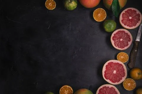 Low key top view of citrus fruits background. Mix of cutted grapefruits and m Stock Photos