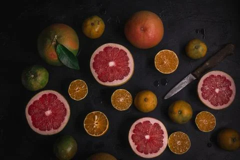 Low key top view of citrus fruits background. Mix of cutted grapefruits and m Stock Photos